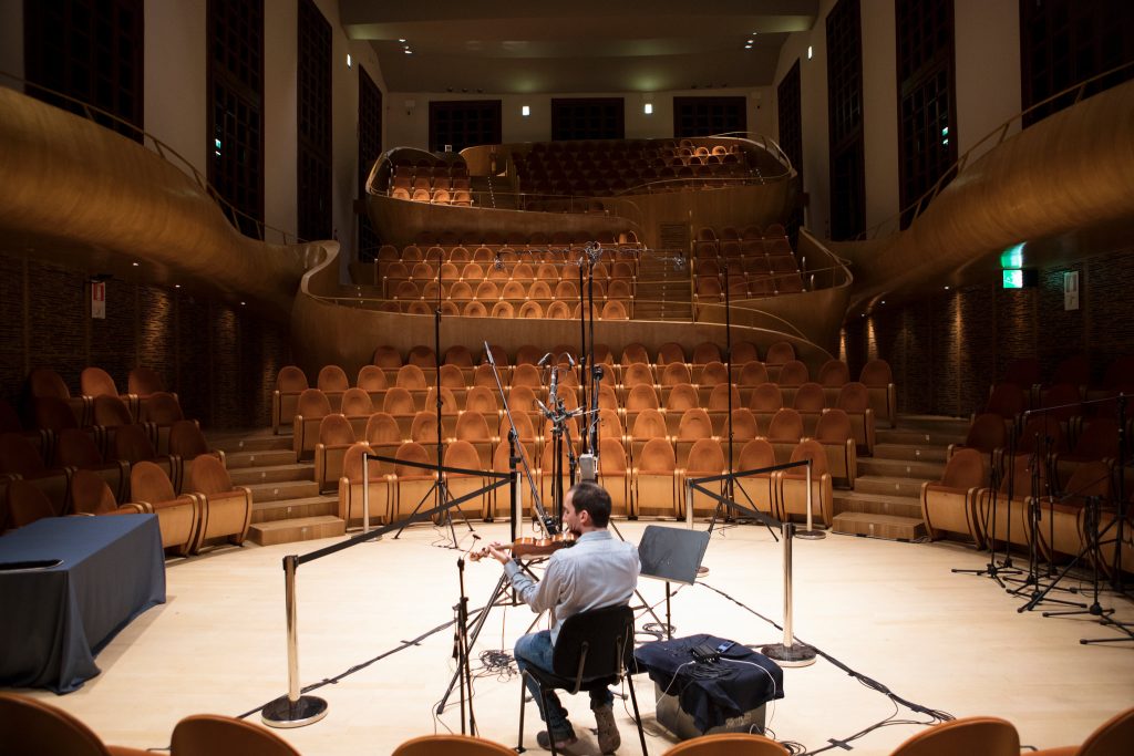Gabriele Schiavi, 31, playing in Auditorium Giovanni Arvedi, the concert hall of the Museo del Violino, in a recording for the “Stradivarius Sound Bank.” The 464-seat Auditorium Arvedi was designed around the sound of the instruments. For the recordings, every light bulb in the hall was unscrewed to eliminate a faint buzzing sound.Isabella de Maddalena for The New York Times